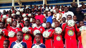 Some of the participating boys displaying their ball-gift. Dr Ifeanyi Ubah and Greek Consular General, Lykourgos Antonios Kaplanis (middle)