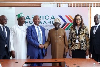 President Bola Tinubu in handshake with CAF president, Patrice Motsepe